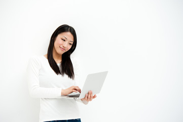 attractive asian woman using laptop in the white room