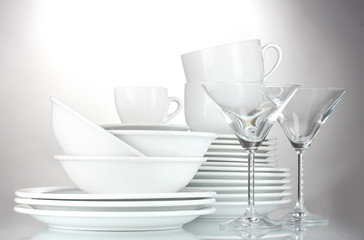 empty bowls, plates, cups and glasses on grey background