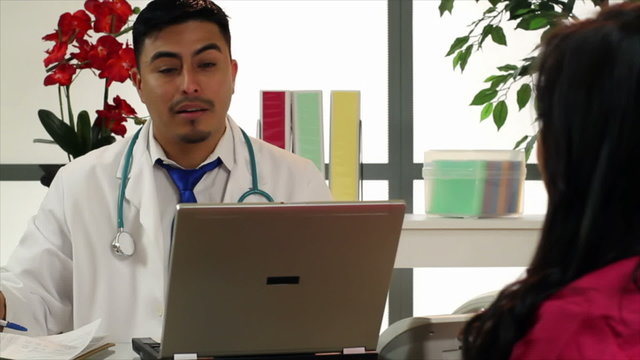 Hispanic doctor in his office talks to woman