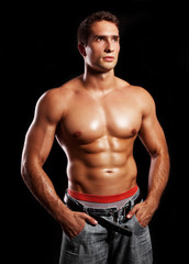 Fototapeta handsome powerful muscular man isolated on black obraz