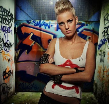 Punk girl on graffiti painted gateway