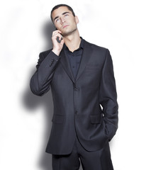 Elegant young businessman talking over cellphone - obrazy, fototapety, plakaty