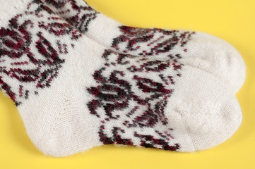 Knitted wool socks on a yellow background
