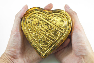 Hands holding golden heart