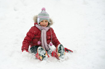 Fototapeta na wymiar Young girl sliding in the snow.