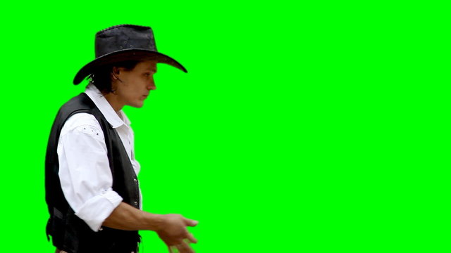 Cowboy on green background shoots from gun