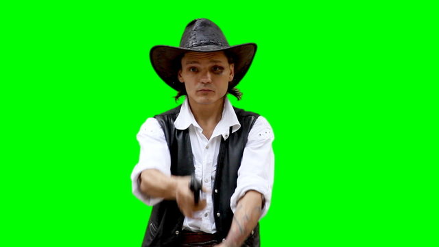 Cowboy on green background shoots from gun