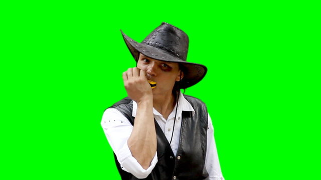 Cowboy on green background plays on harmonica harp