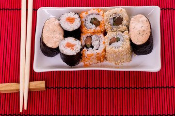 Set of sushi rolls on the white plate with flowers