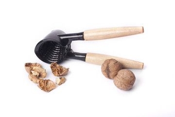 Cracking walnuts with nutcracker over white background