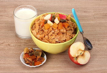 tasty cornflakes in bowl with dried fruits, glass of milk