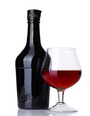 Glass of brandy and bottle isolated on white