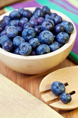 Blueberries in bowl on a wooden table,  selective focus