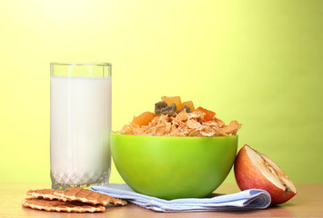 tasty cornflakes in green bowl, apple and glass of milk