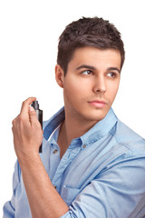 Handsome young man using perfume