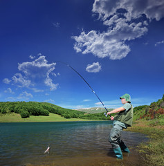 Fisherman fishing on a Mavrovo lake, Macedonia