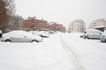 Street view with cars buried by the snow.