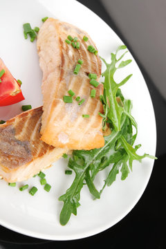 salmon fillet garnished with rocula leaves