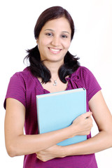 Smiling successful young student holding text books