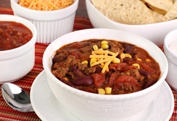 Taco Soup with shredded cheddar and condiments.
