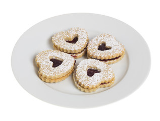 White plate with four heart shaped cookies