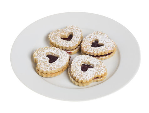 White plate with four heart shaped cookies