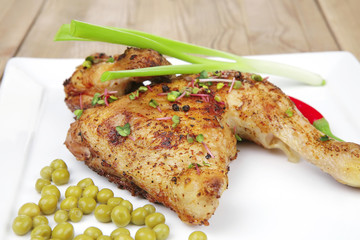 chicken garnished with green sweet peas and red hot pepper
