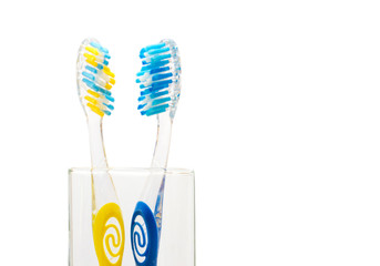 two toothbrushes in a glass on a white background