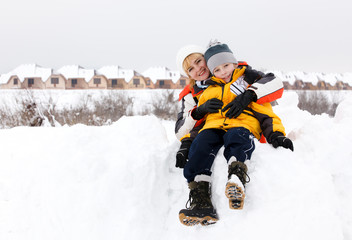 Fototapeta na wymiar Young mother and her son enjoying beautiful winter day outdoors