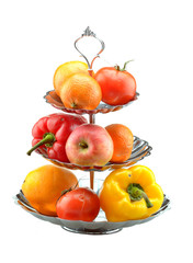 peppers, tomato, orange and apple on a vase isolated