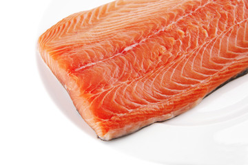 fresh uncooked salmon fillet on white plate