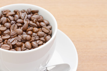 Close up  coffee beans in white cup and saucer