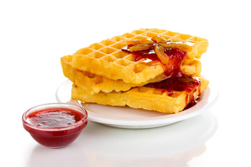 Tasty waffles with jam on plate isolated on white