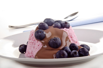 strawberry pudding with blueberries and chocolate sauce