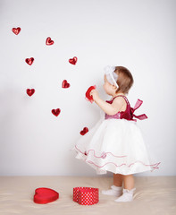 Little girl with flying hearts in studio