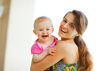 Portrait of laughing mother and baby
