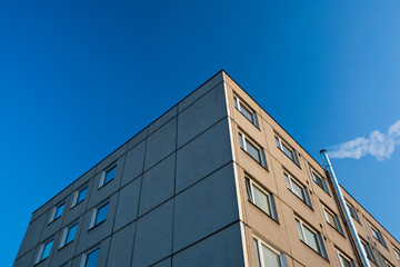 Fototapeta premium smoke/flue gases going out of a chimney by an apartment building