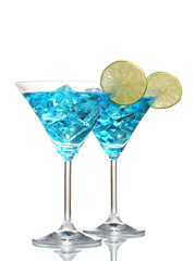 Blue cocktail in martini glasses with ice isolated on white