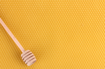 Fototapeta na wymiar yellow beautiful honeycomb and wooden honey drizzler .