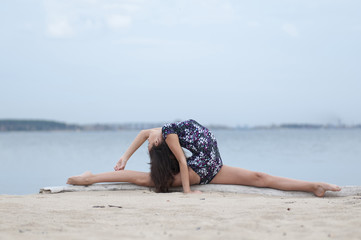 Young gymnast girl dance on beach