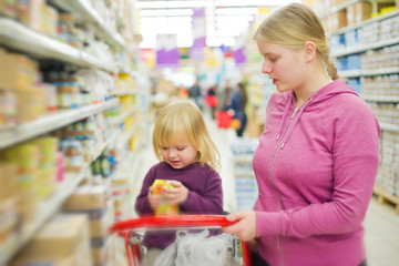 Mother and daughter in baby food section in supermarket