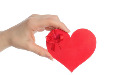 Hand holds paper heart with bow on white background