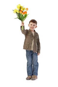 Cute little kid with bouquet of tulips smiling