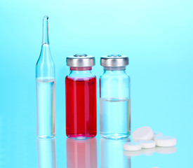 Tablets and ampoules on blue background