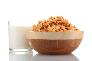 tasty cornflakes in wooden bowl and glass of milk isolated