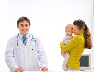 Fototapeta premium Portrait of pediatric doctor and mother with baby on examination