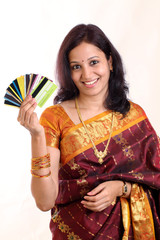 Happy traditional woman holding debit & credit cards
