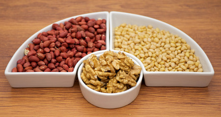 White plats with walnuts, peanut and pine nut