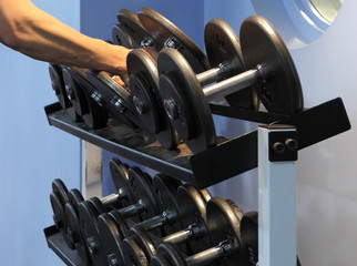 Two dumbbells being lifted from the rack.