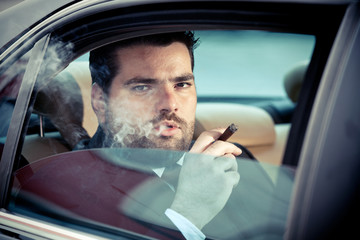 Man in the back seat of a car smoking